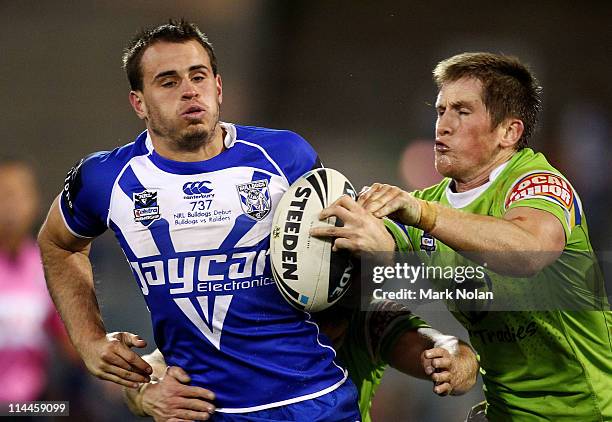 Josh Reynolds of the Bulldogs makes a line break as Josh McCrone of the Raiders attempts to tackle during the round 11 NRL match between the Canberra...