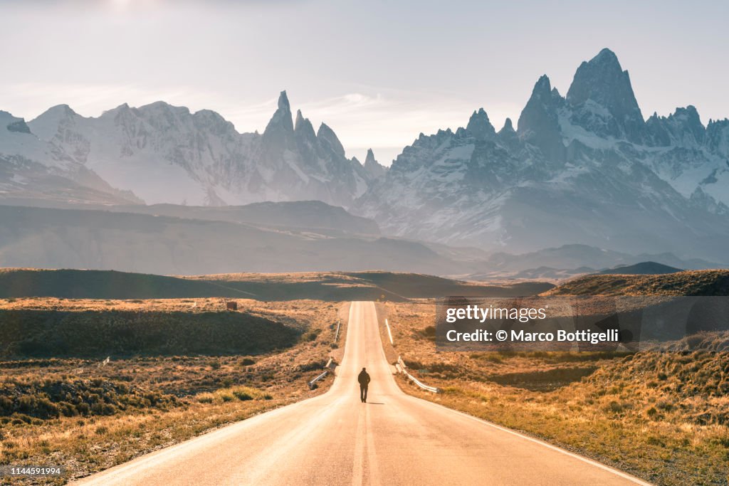 Man walking on the road to Fitz Roy range, Patagonia Argentina