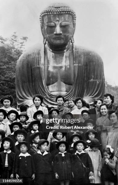 Japanese elementary school students on a field trip to Kamakura pose for a group photo in 1953 with teachers and parents who served as chaperones....