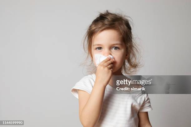 niña limpiando su nariz - haemophilus influenzae fotografías e imágenes de stock