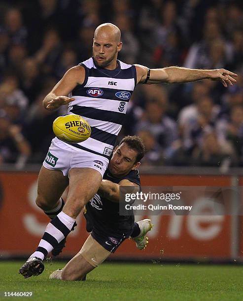 Paul Chapman of the Cats kicks whilst being tackled by Heath Scotland of the Blues during the round nine AFL match between the Carlton Blues and the...