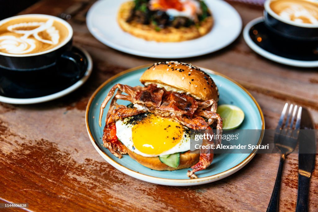 Breakfast in a cafe with crab burger and sunny side up egg