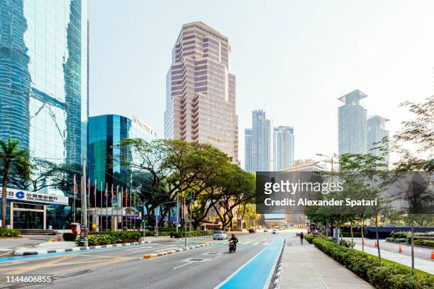 street with modern skyscrapers in kuala lumpur downtown on a sunny day with clear sky, malaysia - kuala lumpur stock pictures, royalty-free photos & images