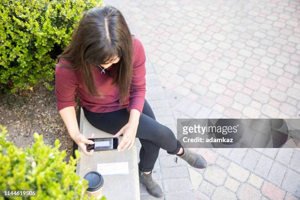 mulher que depositando verificações com smartphone - guia de depósito - fotografias e filmes do acervo