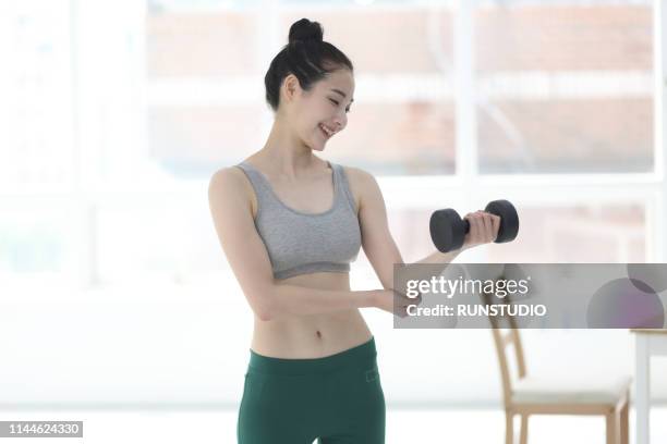 woman lifting dumbbell at home - japan training session stock pictures, royalty-free photos & images