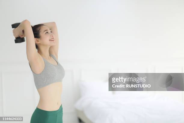 woman lifting weights in bedroom - this morning 2017 ストックフォトと画像