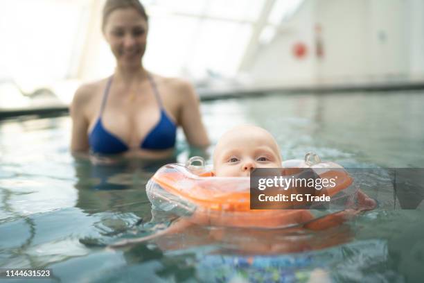 mama mit ihrem baby-sohn im pool - babyschwimmen stock-fotos und bilder