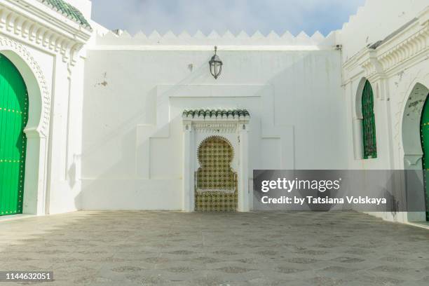 ancient fortified wall with arch decor in the medina of asilah, morocco - arabic style stock pictures, royalty-free photos & images