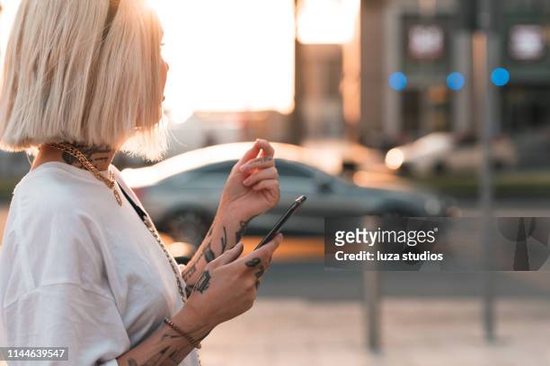 donna che usa un'app di ride-sharing sul suo telefono - dubai taxi foto e immagini stock
