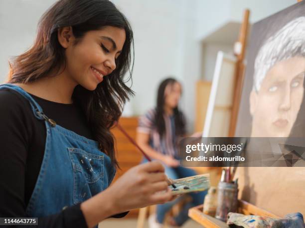 glückliche latinierinnen bei der arbeit an einem gemälde - kunst stock-fotos und bilder