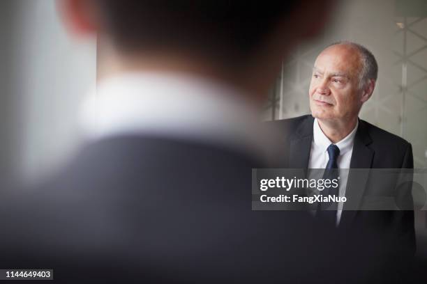 senior zakenman weg te kijken op office meeting - successor stockfoto's en -beelden