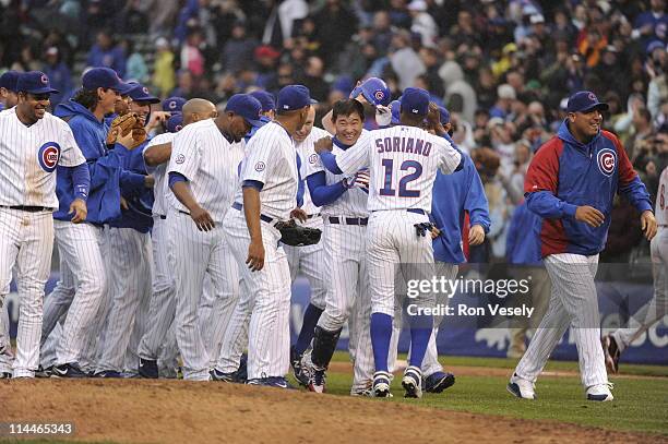 Kosuke Fukudome of the Chicago Cubs is mobbed by teammates after hitting a walk-off game winning single off of Francisco Cordero of the Cincinnati...