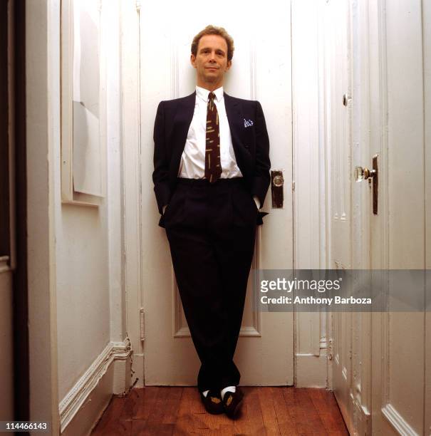 Portrait of American theatre and film actor Joel Grey, dressed in a suit with his hands in his pockets, as he leans against a closed door, New York,...