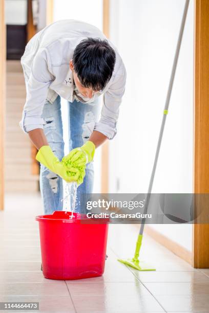 volwassen vrouw reinigings vloer met een mop - daily bucket stockfoto's en -beelden