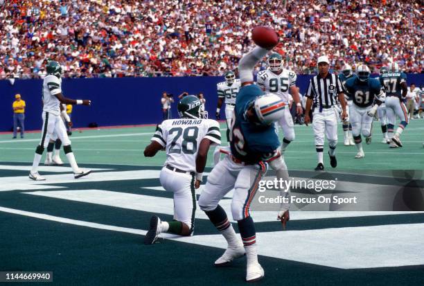 Mark Clayton of the Miami Dolphins celebrates after scoring a touchdown against the New York Jets during an NFL football game November 27, 1988 at...