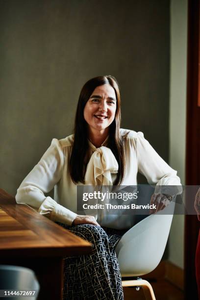 Portrait of smiling mature woman sitting at dining room table