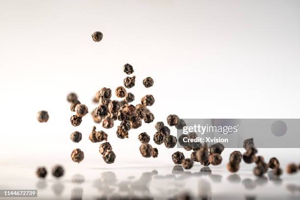 black pepper dancing in mid air with white background captured in high speed  "n - ペッパー ストックフォトと画像