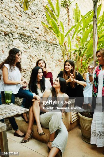 smiling women from multigenerational family hanging out in backyard during dinner party - nosotroscollection stockfoto's en -beelden