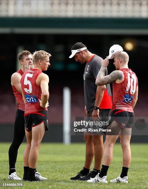 Luke Parker, Isaac Heeney and Zak Jones of the Swans speak with Swans Ruck coach Dean Cox during a Sydney Swans AFL training session at the Sydney...