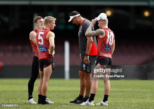 Luke Parker, Isaac Heeney and Zak Jones of the Swans speak with Swans Ruck coach Dean Cox during a Sydney Swans AFL training session at the Sydney...