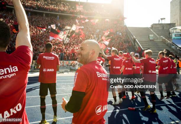 Bayer Leverkusen's Dutch head coach Peter Bosz and players celebrate with their fans after the German first division Bundesliga football match Hertha...