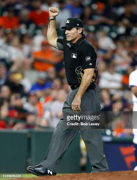 Home plate umpire Angel Hernandez calls Carlos Correa of the Houston Astros out for batter interference in the seventh inning when he reached and...
