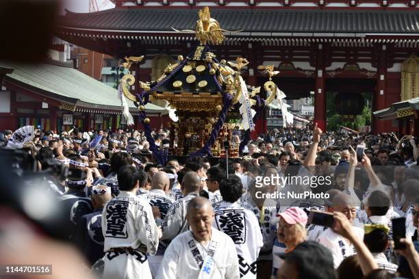 Participants clad in traditional happi coats carry a portable shrine in front of Sensoji Temple during a festival &quot;Sanja Matsuri&quot; on May...