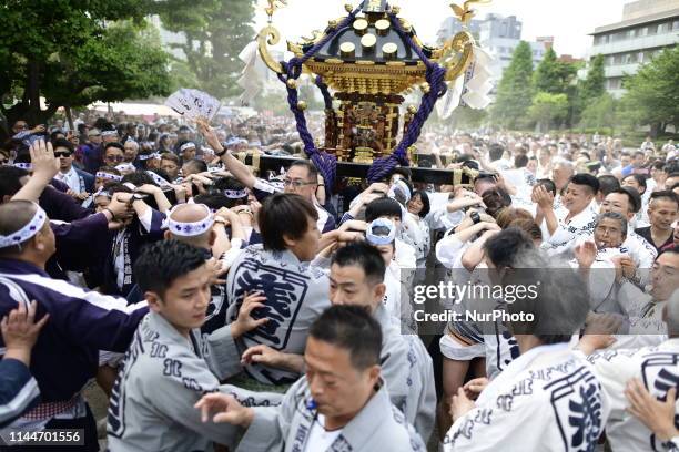 Participants clad in traditional happi coats carry a portable shrine in Sensoji Temple during Tokyo's one of the largest three day festival called...