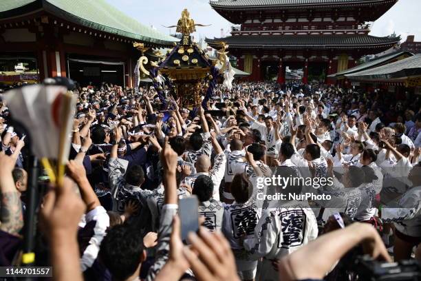 Participants clad in traditional happi coats carry a portable shrine in front of Sensoji Temple during a festival &quot;Sanja Matsuri&quot; on May...