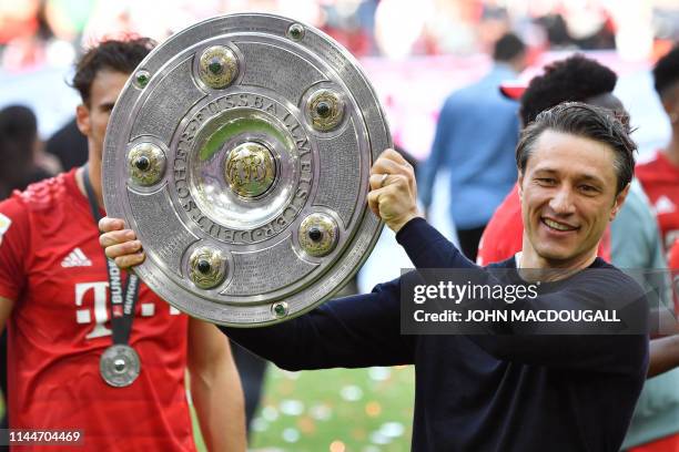 Bayern Munich's Croatian headcoach Niko Kovac celebrates with the trophy after his team's championship victory after the German First division...