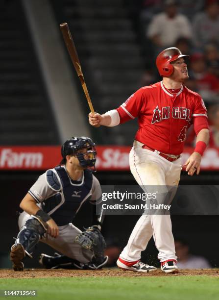 Justin Bour of the Los Angeles Angels of Anaheim reacts to hitting a grand slam as Austin Romine of the New York Yankees looks on during the eighth...