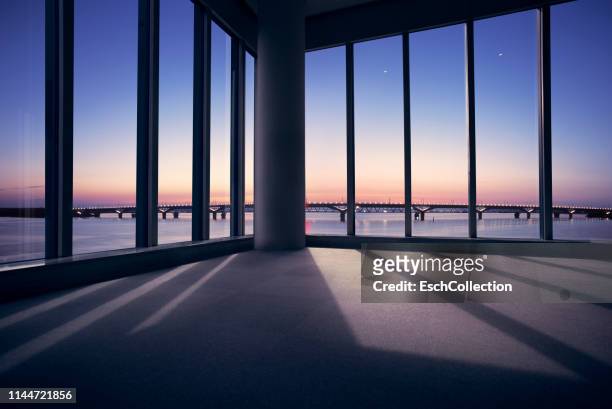 modern office with window view of large bridge across river - empty office window stock pictures, royalty-free photos & images