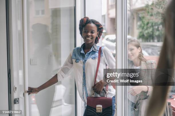 los clientes que entran en la tienda - entrando fotografías e imágenes de stock