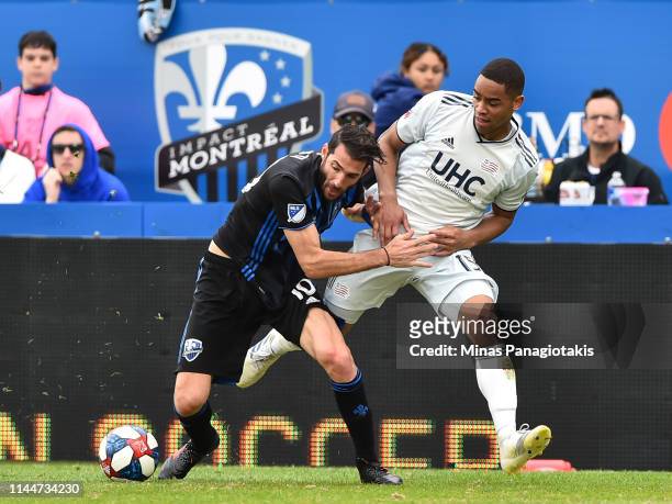 Ignacio Piatti of the Montreal Impact battles for the ball with Brandon Bye of the New England Revolution in the second half during the MLS game at...