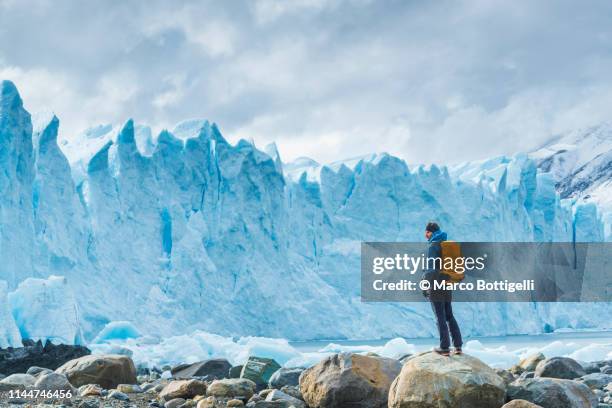 tourist admiring the front of perito moreno glacier, argentina - エルカラファテ ストックフォトと画像