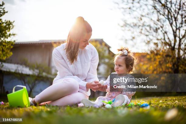 jugando en el césped junto a la casa durante la pascua - egg hunting fotografías e imágenes de stock
