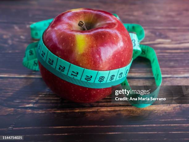 an apple and a tape measure. diet concept - bulimie stock pictures, royalty-free photos & images