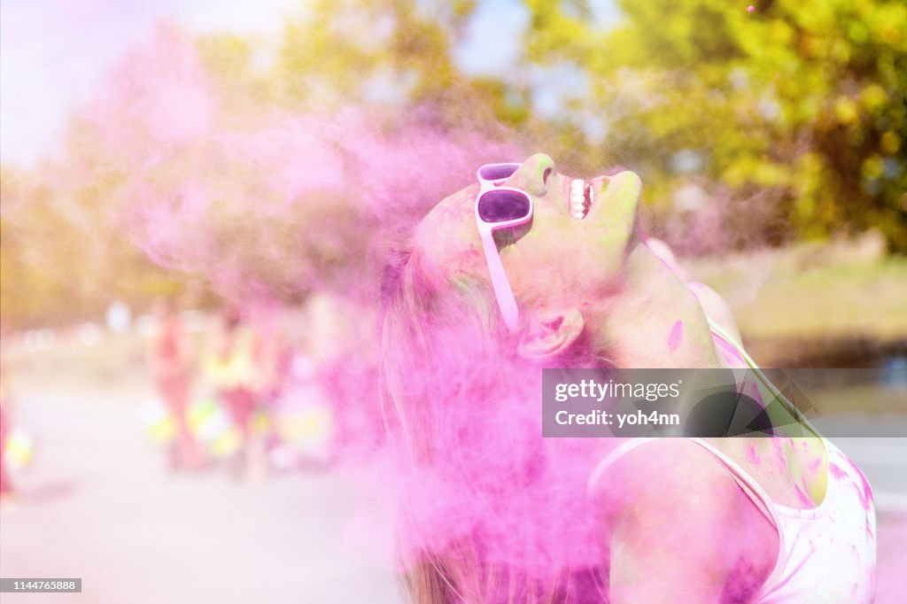 Joyful woman enjoying the color powder festival