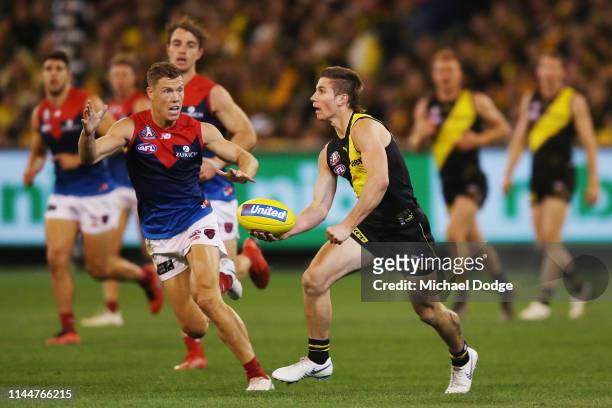 Liam Baker of the Tigers runs with the ball from Jake Melksham of the Demons during the round 6 AFL match between Richmond and Melbourne at Melbourne...