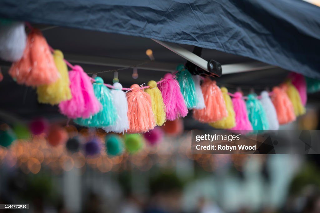 Colourful tassles hang from a tent during a market