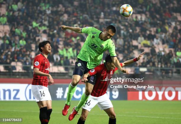 Kim Shin-wook of Jeonbuk Hyundai Motors competes for the ball with Ryota Moriwaki of Urawa Red Diamonds during the AFC Champions League Group G match...