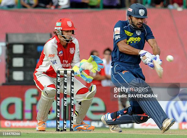 PACKAGEKings XI Punjab wicketkeeper Adam Gilchrist looks on as Deccan Chargers batsman Shakar Dhawan plays a shot during the IPL cricket match...