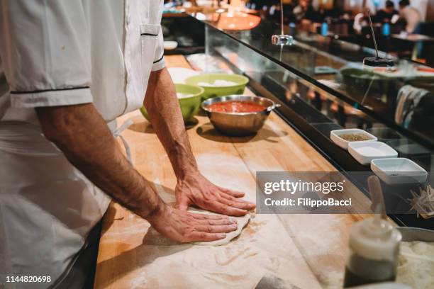 pizza chef preparing pizza at the restaurant - pizza chef stock pictures, royalty-free photos & images