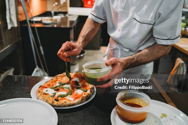 pizza chef preparing pizza at the restaurant - pizza chef stock pictures, royalty-free photos & images