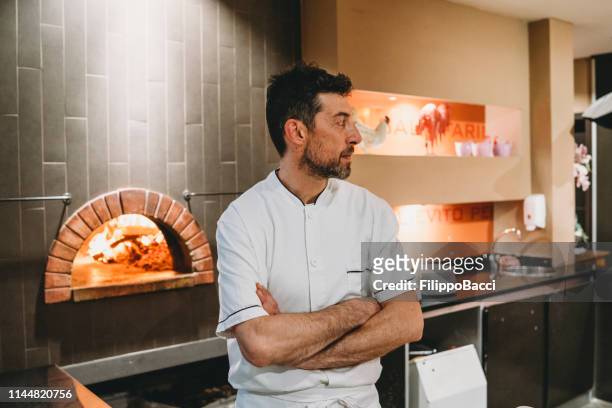 portrait of a pizza chef inside his pizzeria - pizza chef stock pictures, royalty-free photos & images