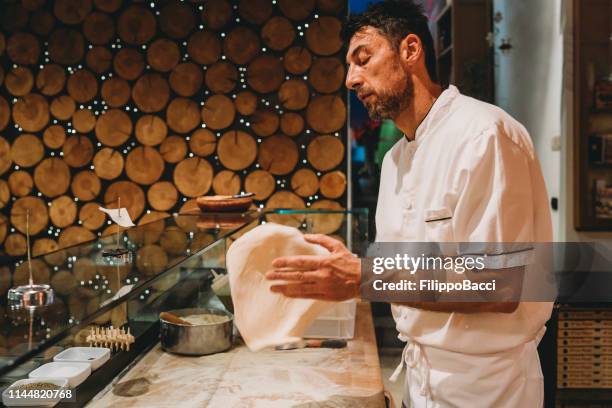 pizza chef preparing a pizza at the restaurant - pizza chef stock pictures, royalty-free photos & images