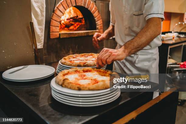 pizza chef preparing pizza at the restaurant - napoli pizza stock pictures, royalty-free photos & images