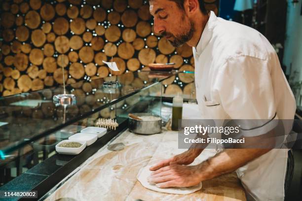 pizza chef preparing a pizza at the restaurant - pizza chef stock pictures, royalty-free photos & images