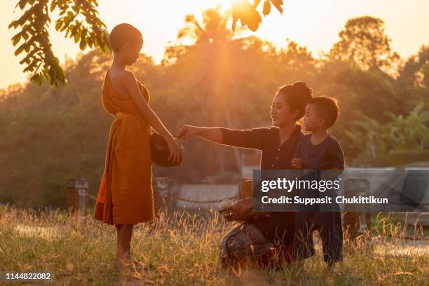 buddhist elder novice. the family children woman putting food offerings - cambodian buddhist stock pictures, royalty-free photos & images