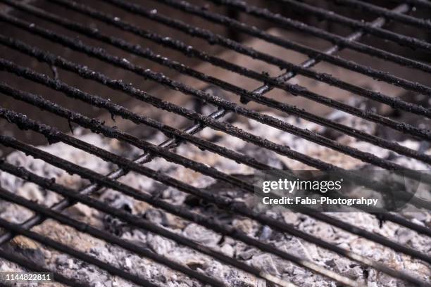 high angle view of burning charcoal with metallic grate - metal grate fotografías e imágenes de stock